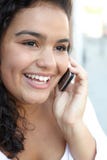 Giovane donna felice che per mezzo del telefono cellulare fotografie stock Giovane donna felice che per mezzo del telefono cellulare fotografie stock