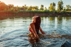 Giovane donna nel saltare del bikini dell'acqua e nella fabbricazione della spruzzata Vacanza di estate immagine stock Giovane donna nel saltare del bikini dell'acqua e nella fabbricazione della spruzzata Vacanza di estate immagine stock