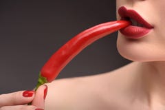 Giovane donna sexy che mangia peperoncino rosso immagine stock Giovane donna sexy che mangia peperoncino rosso immagine stock