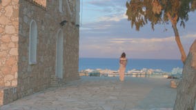 Giovane donna sola che esamina il cielo di sera sopra il mare Vacanza al centro balneare stock footage Giovane donna sola che esamina il cielo di sera sopra il mare Vacanza al centro balneare stock footage