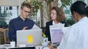 Giovane gruppo di corsa mista di gente di affari che lavora per il progetto Start-up in ufficio 4K video d archivio Giovane gruppo di corsa mista di gente di affari che lavora per il progetto Start-up in ufficio 4K video d archivio