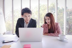 Giovane lavoro asiatico dell'uomo di affari con il computer portatile nell'ufficio immagine stock libera da diritti Giovane lavoro asiatico dell'uomo di affari con il computer portatile nell'ufficio immagine stock libera da diritti