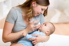 Giovane madre che alimenta il suo bambino adorabile fotografia stock libera da diritti Giovane madre che alimenta il suo bambino adorabile fotografia stock libera da diritti