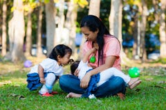 Giovane madre che alimenta il suo bambino nel parco immagine stock libera da diritti Giovane madre che alimenta il suo bambino nel parco immagine stock libera da diritti