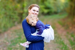 Giovane madre felice divertendosi la figlia sveglia del bambino, ritratto della famiglia insieme Donna con la bella neonata in na immagini stock Giovane madre felice divertendosi la figlia sveglia del bambino, ritratto della famiglia insieme Donna con la bella neonata in na immagini stock