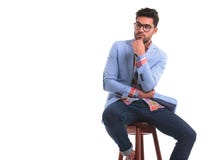 Giovane pensieroso che si siede su una sedia immagini stock libere da diritti Giovane pensieroso che si siede su una sedia immagini stock libere da diritti