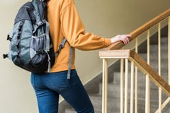 Giovane studente di college femminile solo depresso unrecognisable che cammina sulle scale alla sua scuola fotografia stock Giovane studente di college femminile solo depresso unrecognisable che cammina sulle scale alla sua scuola fotografia stock