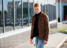 Giovane uomo alla moda bello in rivestimento marrone nel tempo di autunno all'aperto nello stile casuale Immagini Stock Giovane uomo alla moda bello in rivestimento marrone nel tempo di autunno all'aperto nello stile casuale Immagini Stock