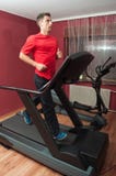 Giovane uomo bello che funziona sulla pedana mobile in ginnastica fotografia stock libera da diritti Giovane uomo bello che funziona sulla pedana mobile in ginnastica fotografia stock libera da diritti