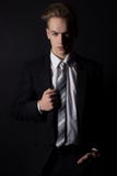 Giovane uomo bello in un vestito ed in una camicia bianca e legame nello stile convenzionale nello studio su un fondo nero fotografia stock libera da diritti Giovane uomo bello in un vestito ed in una camicia bianca e legame nello stile convenzionale nello studio su un fondo nero fotografia stock libera da diritti