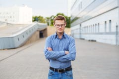 Giovane uomo d'affari sicuro che vi esamina con le sue armi attraversate immagine stock libera da diritti Giovane uomo d'affari sicuro che vi esamina con le sue armi attraversate immagine stock libera da diritti
