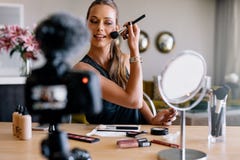 Giovane vlogger femminile che registra una radiodiffusione di trucco fotografie stock Giovane vlogger femminile che registra una radiodiffusione di trucco fotografie stock