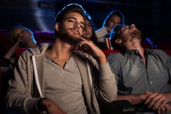 Giovani che guardano un film noioso al cinema Fotografie Stock Libere da Diritti Giovani che guardano un film noioso al cinema Fotografie Stock Libere da Diritti