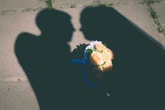Giovani coppie di nozze che godono dei momenti romantici fuori su un prato di estate fotografia stock libera da diritti Giovani coppie di nozze che godono dei momenti romantici fuori su un prato di estate fotografia stock libera da diritti