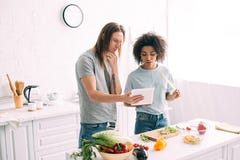 giovani coppie multiculturali che esaminano ricetta sulla compressa digitale e sulla cottura fotografia stock libera da diritti giovani coppie multiculturali che esaminano ricetta sulla compressa digitale e sulla cottura fotografia stock libera da diritti