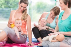 Giovani donne che praticano massaggio per i loro bambini fotografia stock Giovani donne che praticano massaggio per i loro bambini fotografia stock