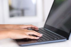 Giovani mani femminili che funzionano e che scrivono sulla tastiera del computer portatile in ufficio fotografia stock libera da diritti Giovani mani femminili che funzionano e che scrivono sulla tastiera del computer portatile in ufficio fotografia stock libera da diritti
