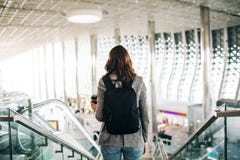 Girl at the airport from the back, holding coffee cup. royalty free stock photo Girl at the airport from the back, holding coffee cup. royalty free stock photo
