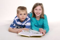 Girl And Boy Reading Book. Stock Photo