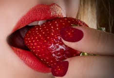 The girls biting lips red and ripe berry. royalty free stock photo The girls biting lips red and ripe berry. royalty free stock photo