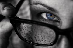A girl with blue eyes looks over her glasses stock photography A girl with blue eyes looks over her glasses stock photography