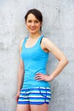 Girl in blue tank top and shorts over the wall smiling. Royalty Free Stock Image Girl in blue tank top and shorts over the wall smiling. Royalty Free Stock Image