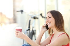 Girl calling on the mobile phone and drinking coffee royalty free stock photography Girl calling on the mobile phone and drinking coffee royalty free stock photography