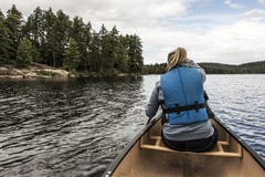 Girl canoeing with Canoe on the lake of two rivers in the algonquin national park in Ontario Canada on sunny cloudy day Royalty Free Stock Photography Girl canoeing with Canoe on the lake of two rivers in the algonquin national park in Ontario Canada on sunny cloudy day Royalty Free Stock Photography