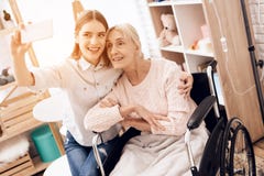 Girl is caring for elderly woman at home. They are taking selfie on phone. stock photography Girl is caring for elderly woman at home. They are taking selfie on phone. stock photography