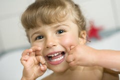 Girl cleaning teeth by dental floss