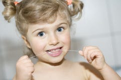 Girl cleaning teeth by dental floss