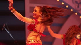 Girl dancing on stage in a red national Indian suit