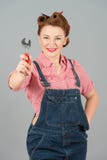 Girl dressed in pin-up style with wrench in hand in front of us. Caucasian brunette model posing. royalty free stock image Girl dressed in pin-up style with wrench in hand in front of us. Caucasian brunette model posing. royalty free stock image