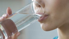 Girl drinking clean fresh mineral water glass, aqua body balance, hydration