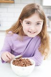 Girl Eating Bowl Of Sugary Breakfast Cereal In Kitchen royalty free stock image Girl Eating Bowl Of Sugary Breakfast Cereal In Kitchen royalty free stock image