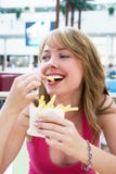 Girl Eating French-fries Stock Images