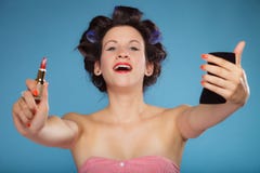 Girl in hair curlers applying red lipstick stock image Girl in hair curlers applying red lipstick stock image
