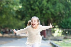 Girl on happy smiling face, nature on background. Child happy and cheerful enjoy walk in park. Happiness concept. Kid royalty free stock images Girl on happy smiling face, nature on background. Child happy and cheerful enjoy walk in park. Happiness concept. Kid royalty free stock images