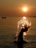 Girl have a fun in sea at sunset