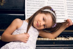 Girl In A Beautiful Dress Sits At The Piano Stock Images