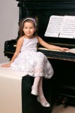 Girl In A Black Dress Sitting Near The Piano Stock Image