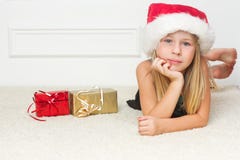 Girl In A Christmas Cap Lies Royalty Free Stock Photos