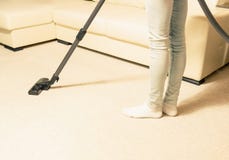 Girl in jeans vacuuming the house. bright carpet royalty free stock photography Girl in jeans vacuuming the house. bright carpet royalty free stock photography