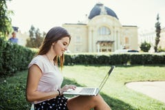 Young woman with laptop sitting on grass, picture with place for text stock images Young woman with laptop sitting on grass, picture with place for text stock images