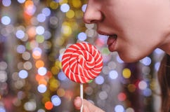 A girl licks a lollipop Royalty Free Stock Image A girl licks a lollipop Royalty Free Stock Image