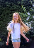 Girl with long blond hair dances in the garden on a beautiful spring day and is cheerful stock photography Girl with long blond hair dances in the garden on a beautiful spring day and is cheerful stock photography
