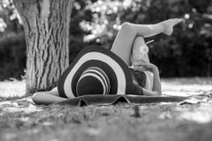 Girl lying relaxing in her back under a tree with a drink and br Royalty Free Stock Photo Girl lying relaxing in her back under a tree with a drink and br Royalty Free Stock Photo