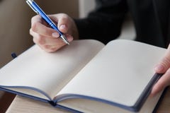 The girl makes entry in a notebook. close up stock image The girl makes entry in a notebook. close up stock image