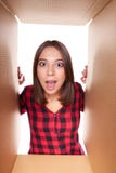 Girl opening a carton box and looking inside royalty free stock photography Girl opening a carton box and looking inside royalty free stock photography