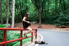 Girl playing guitar on a road side royalty free stock image Girl playing guitar on a road side royalty free stock image